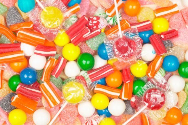 Imagem de vários doces como balas, pirulitos e gomas, uma das oferendas para o Erê Pedrinho da Umbanda.