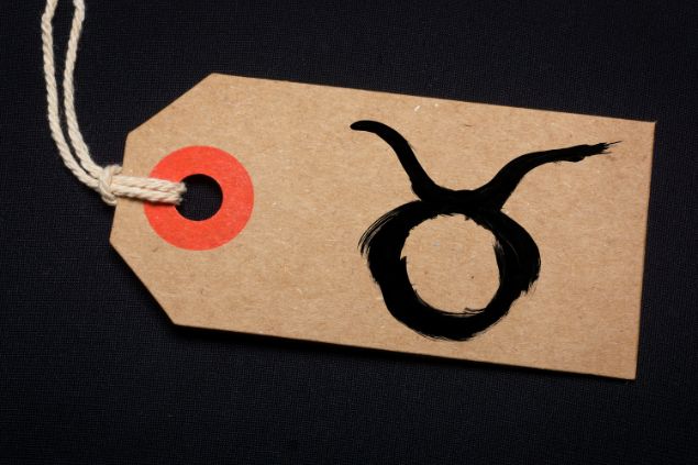 Imagem de fundo preto e em destaque uma etiqueta com o glifo de touro.