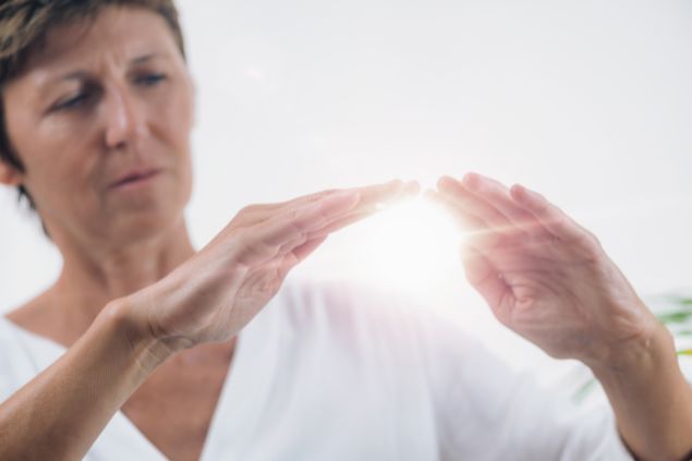 Imagem de uma terapeuta emitindo o reiki à distância