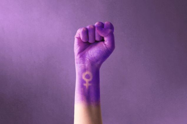 Imagem de punho roxo levantado de uma mulher para o dia internacional da mulher e o movimento feminista, celebrado em 8 de março, trazendo o simbolismo pelo feminismo, independência, liberdade, empoderamento e ativismo pelos direitos das mulheres