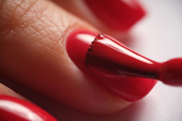 Imagem de uma unha sendo pintada na cor vermelho