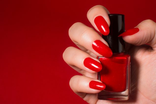 Imagem de uma mão com as unhas pintadas na cor vermelho.