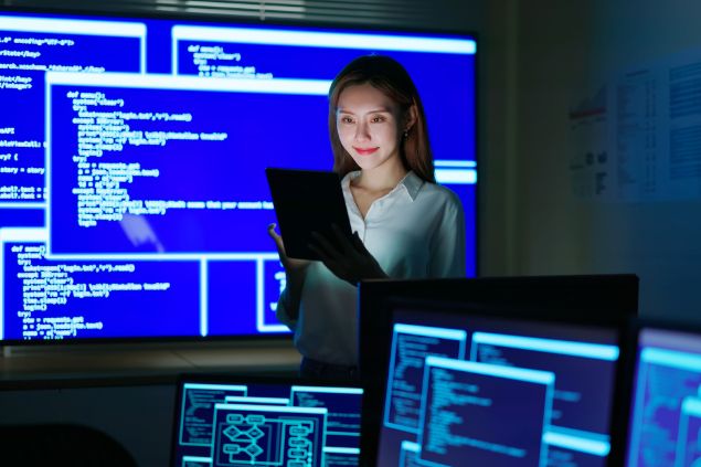 Imagem de uma profissional de analista de sistemas em seu ambiente de trabalho.