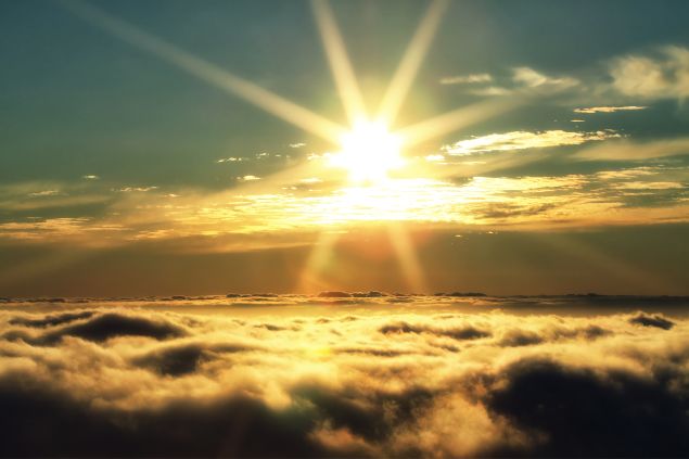 Imagem de um Sol sobre as nuvens. A foto traz o conceito de iluminação divina.