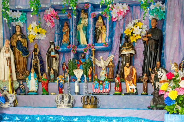 Imagem de um altar com vários santos e outras entidades da Umbanda.