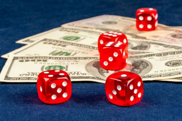 Notas de dinheiro com dados em cima.