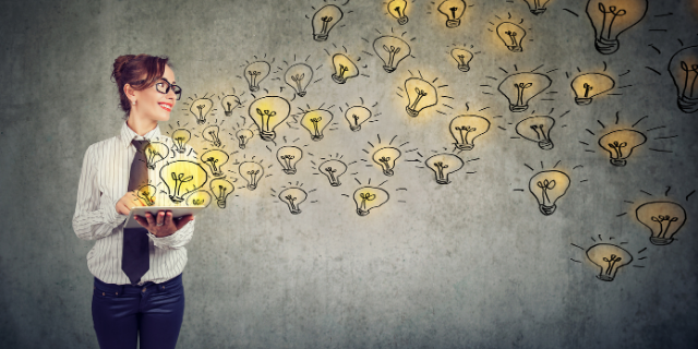 Mulher segura papéis e deles saem símbolos de lâmpadas representativos de ideias.