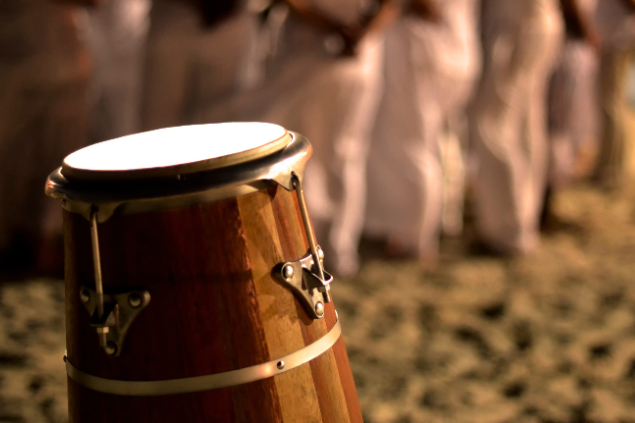 Pessoas na praia com instrumentos da Umbanda