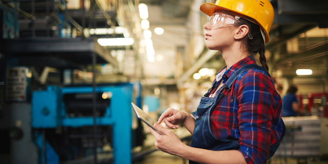 Mulher trabalhando em ambiente industrial. 