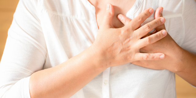 Pessoa pressiona o próprio peito. 