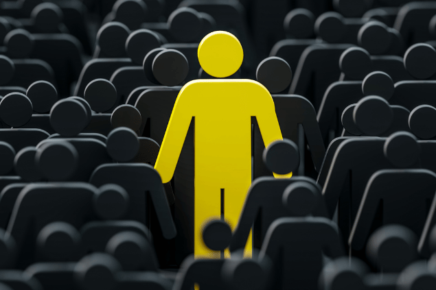 Bonequinho amarelo em meio à bonecos pretos. Conceito de ser diferente. 