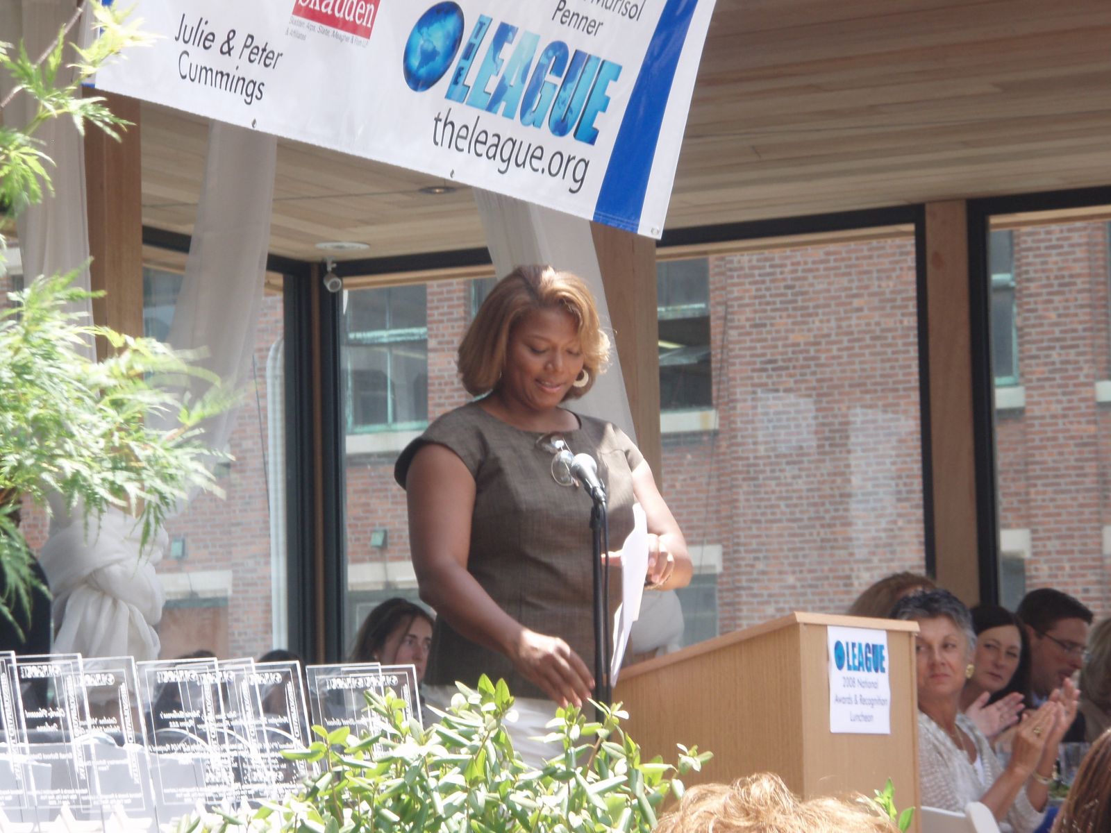 Queen Latifah em um palco falando no microfone