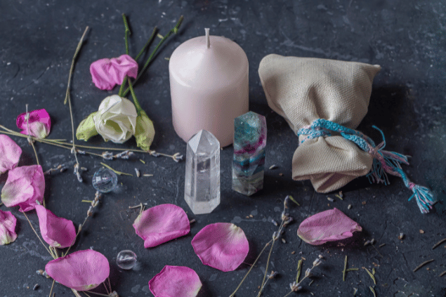 Elena Vafina / Getty Images / Canva Na imagem, há flores, cristais e uma vela em cima de uma mesa.