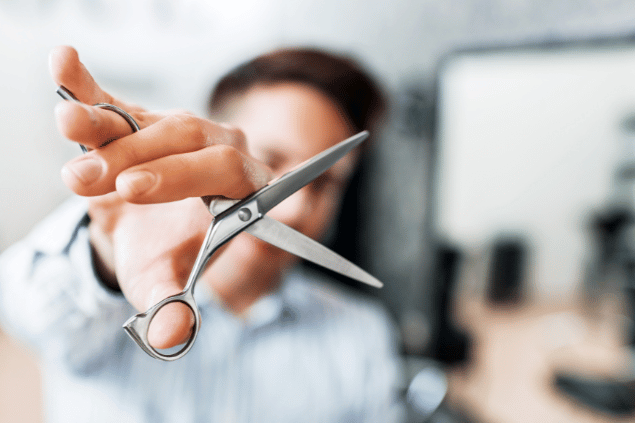 Homem segurando tesoura. 