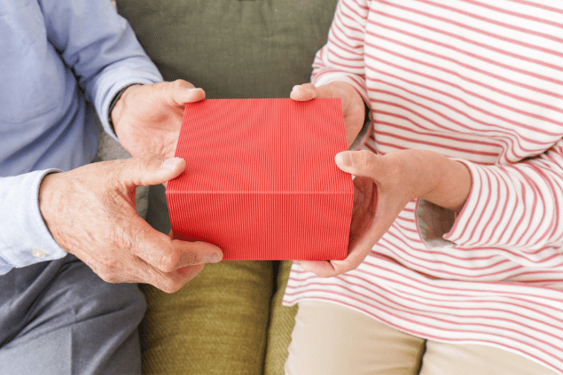 Mulher entregando caixa de presente. 