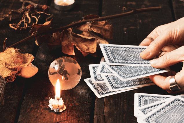 Mulher mexendo em cartas de Tarot