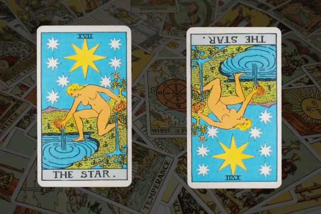 Montagem com a carta A Estrela do Tarot na posição normal e outra carta A Estrela na posição invertida. Ao fundo, há várias cartas de Tarot.
