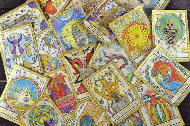 Há várias cartas de Tarot espalhadas sobre uma mesa de madeira.