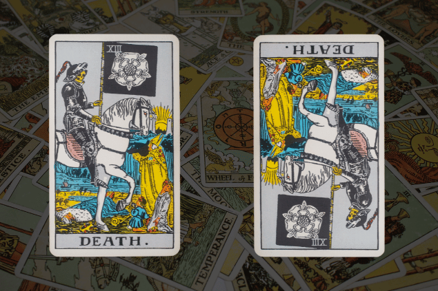 Montagem com a carta A Morte do Tarot na posição normal e outra carta A Morte na posição invertida. Ao fundo, há várias cartas de Tarot.
