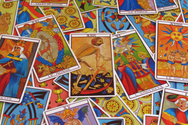 Várias cartas de Tarot estão espalhadas sobre uma mesa.