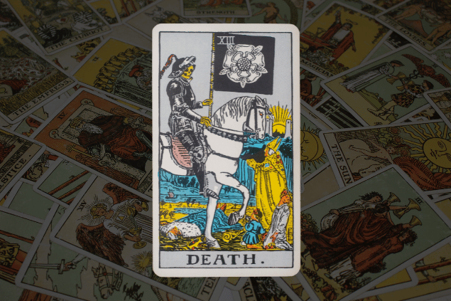 Montagem com a carta A Morte do Tarot na posição normal. Ao fundo, há várias cartas de Tarot.