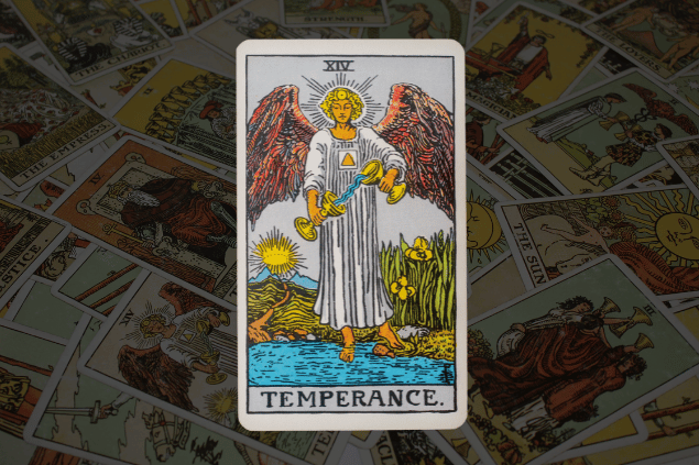 Montagem com a carta A Temperança do Tarot na posição normal. Ao fundo, há várias cartas de Tarot.