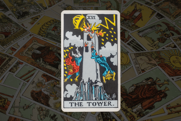 Montagem com a carta A Torre do Tarot na posição normal. Ao fundo, há várias cartas de Tarot.