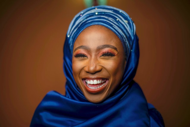 Mulher negra com hijab sorrindo.