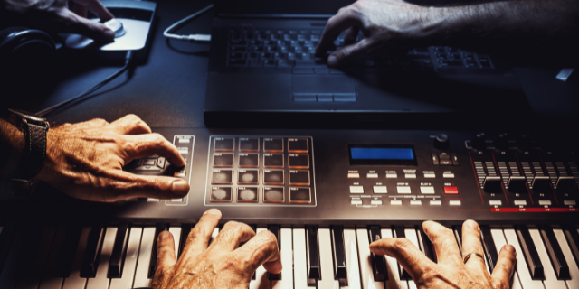 Homem toca teclado. Logo acima, transição para outra imagem, onde um homem mexe em um pedal e computador. 