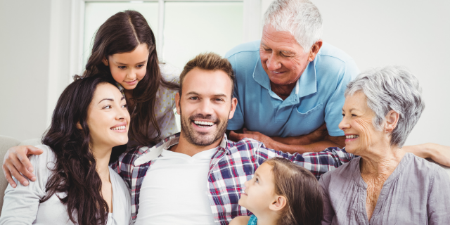 Avós em sofá com duas crianças e dois adultos.