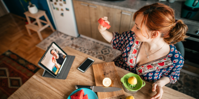 hobo_018 / Canva Mulher em vídeo-chamada com um homem. Eles comem frutas.