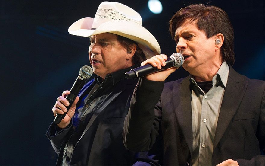 Chitãozinho e Xororó cantando em um palco