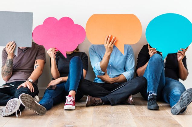 Pessoas sentadas, segurando papéis na frente de seu rosto, representando balões de pensamento e fala.