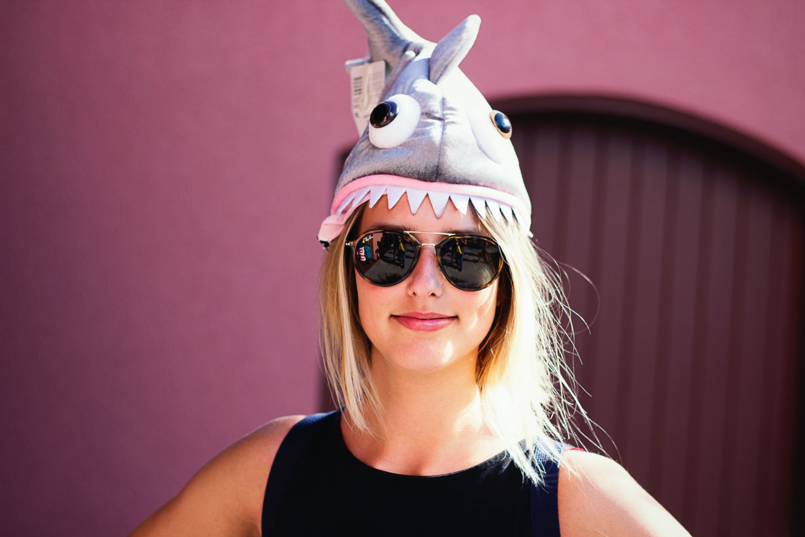 Mulher cm uma pelúcia de tubarão na cabeça