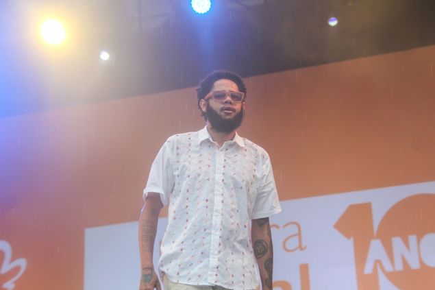 Emicida em cima do palco cantando