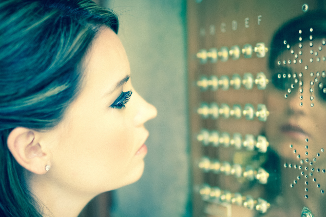 Mulher se olhando em uma estrutura metálica