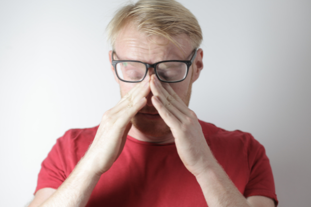 Homem estressado com as mãos no rosto 