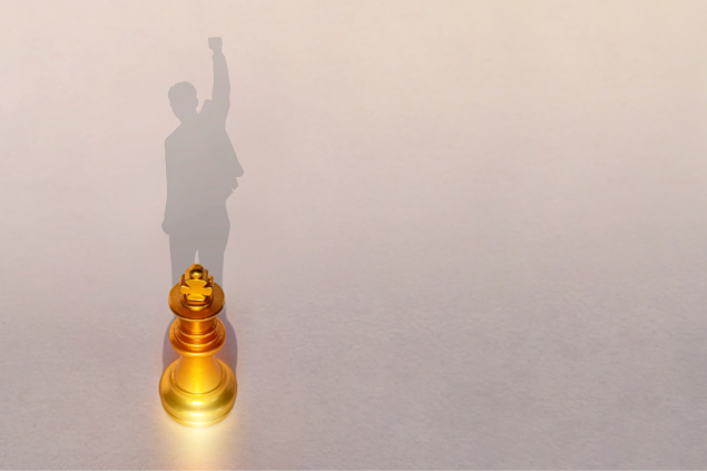 Sombra de uma peça de xadrez formando um homem com a mão para o céu.