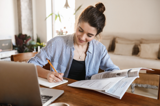 Menina estudando enquanto escreve em um caderno
