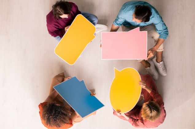 Várias pessoas conversando com balões coloridos