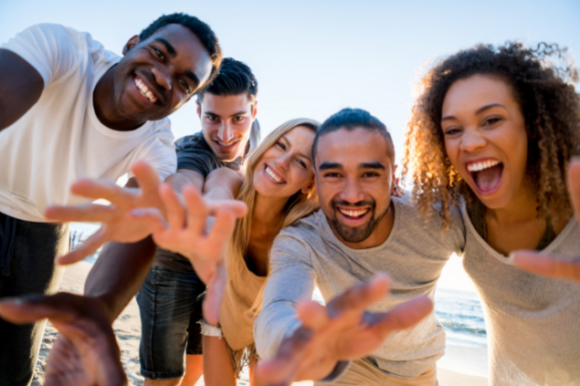 Amigos se divertindo enquanto sorriem e olham para a câmera