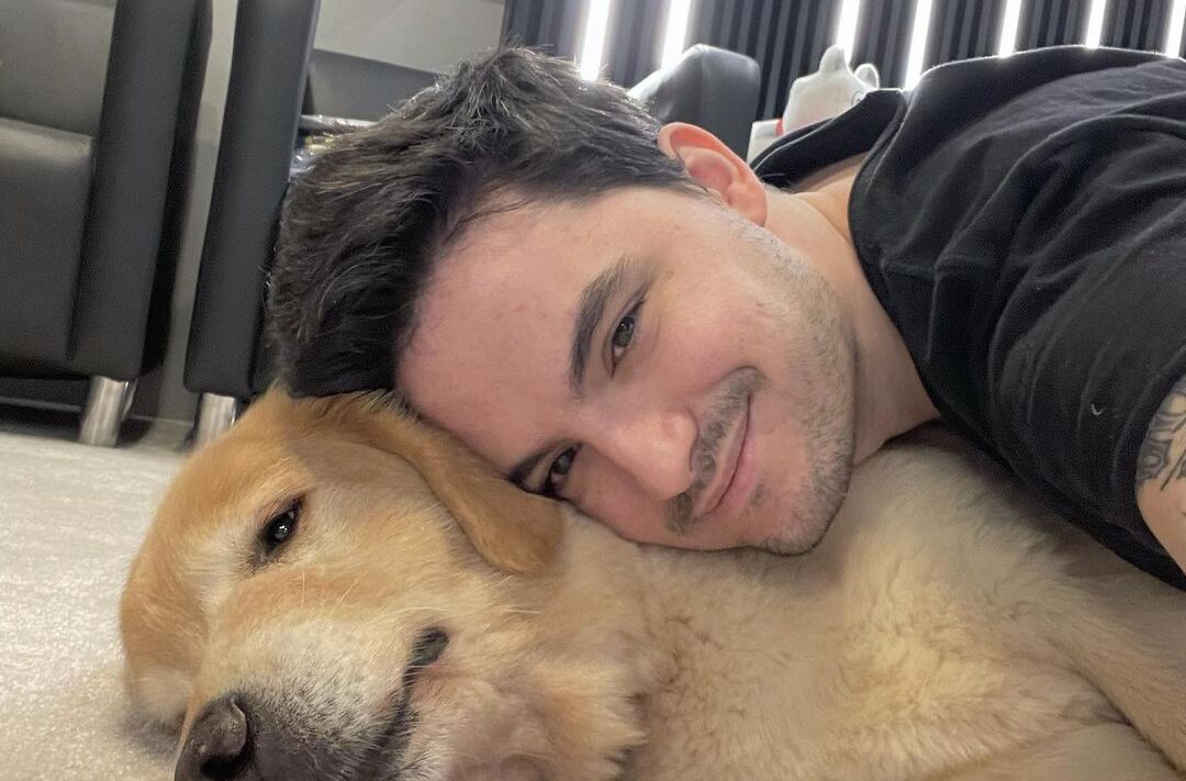 Felipe Neto abraçado com cachorro.
