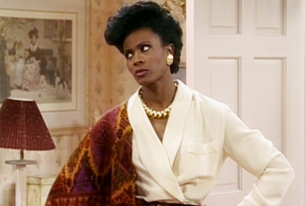 Mulher negra de cabelos pretos e curtos, usando roupas coloridas.