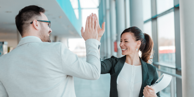 Homem e mulher unem as mãos em um gesto de coleguismo. 