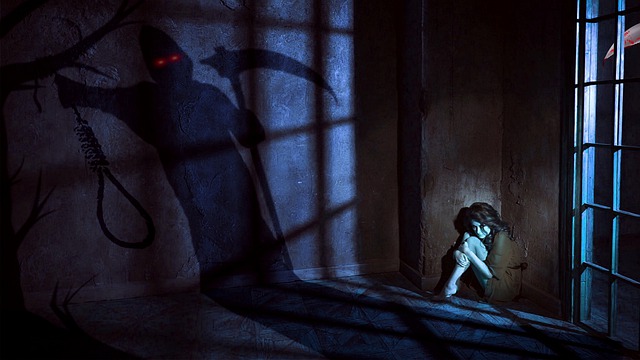 Silhueta de fantasma na parede e pessoa encolhida ao canto 