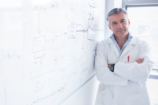 Professor cientista em frente a uma lousa