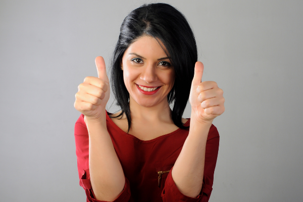 Mulher com os dedões para cima em sinal positivo