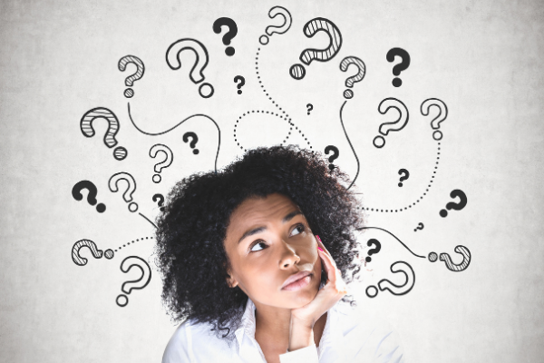 Mulher com expressão pensativa e pontos de interrogação a sua volta