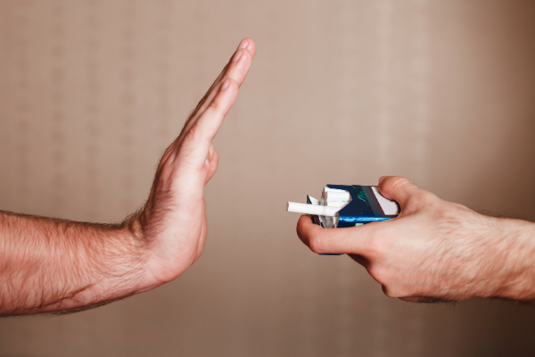 Mão recusando um maço de cigarro