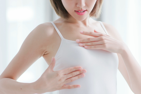 Mulher realizando o autoexame de mama